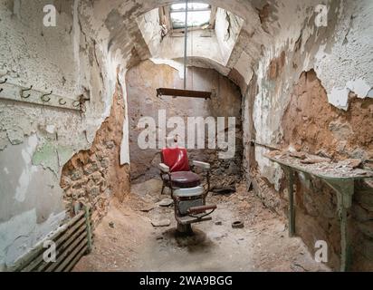 Una cattedra di barbiere in cella vuota del penitenziario di stato orientale, prigione di Philadelphia, Pennsylvania, USA Foto Stock