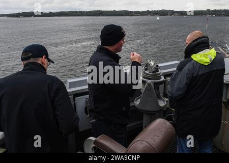 Forze militari STATUNITENSI. 180621FP878-034 KIEL, Germania (21 giugno 2018) Cmdr. Patrick Murphey, ufficiale comandante del cacciatorpediniere missilistico guidato classe Arleigh Burke USS Bainbridge (DDG 96), parla con un pilota tedesco capitano di barca mentre la nave parte da Kiel, Germania, a seguito di una visita programmata al porto il 21 giugno 2018. Bainbridge, portato in patria alla Naval Station Norfolk, sta conducendo operazioni navali nell'area operativa della 6th Fleet degli Stati Uniti a sostegno degli interessi di sicurezza nazionale degli Stati Uniti in Europa e Africa. (Foto U.S. Navy di Mass Communication Specialist 1st Class Theron J. Godbold/rilasciata) Foto Stock