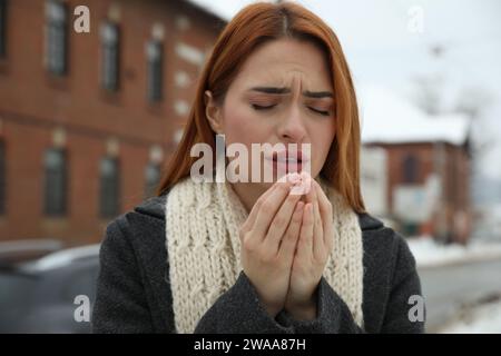 Bella giovane donna che tossisce all'aperto. Sintomi del raffreddore Foto Stock