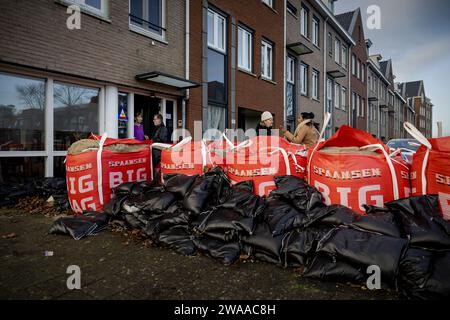 Hoorn, Paesi Bassi. 3 gennaio 2024. HOORN - un dipendente comunale colloca sacchi di sabbia extra come precauzione in una strada allagata vicino al Markermeer dopo la prima tempesta di quest'anno, che è stata chiamata Henk. ANP ROBIN VAN LONKHUIJSEN paesi bassi Out - belgio Out credito: ANP/Alamy Live News Foto Stock