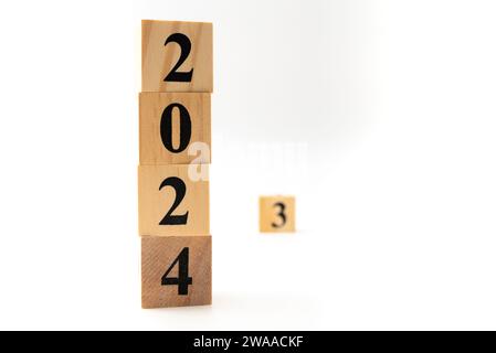 Numero 2024 e numero 3 scritti su blocchi di legno in direzione verticale isolati su sfondo bianco. Foto Stock