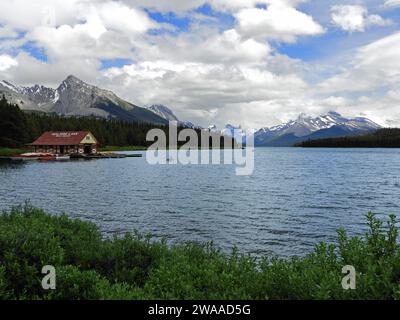 il lago maligne, la casa delle barche del lago maligne e le cime innevate delle montagne in estate nel parco nazionale di jasper, alberta, canada Foto Stock