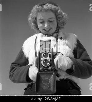L'inverno negli anni '1940 Una giovane donna fotografa in un giorno d'inverno. La fotocamera è una Rolleiflex della società tedesca Rollei per pellicole da 60 mm. 1944. Foto Kristoffersson Rif. F104-4 Foto Stock