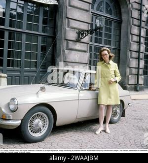 Principessa Christina, signora Magnuson. Sorella del re svedese Carl XVI Gustaf. Nato il 3 agosto 1943. L'auto che ha due anni qui è una MG MGB, un'auto sportiva nel colore Sany Beige, prodotta dalla casa automobilistica britannica MG tra il 1962 e il 1980. Era disponibile come cabriolet e con una carrozzeria coperta a 2+2 posti (GT). Le versioni a sei cilindri prodotte a partire dal 1967-69 furono chiamate MGC. Fotografato all'esterno del Palazzo reale di Stoccolma il 2 giugno 1969 in un vestito d'epoca. Foto Stock