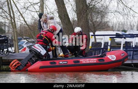 Northamptonshire i vigili del fuoco e i servizi di soccorso salvano le persone dalle case galleggianti del Billing Aquadrome a Northampton dopo che il percorso di atterraggio è stato bloccato a causa dell'innalzamento dell'acqua causato da Storm Henk. Un grave allarme per le inondazioni, che significava pericolo per la vita, era in atto per il fiume Nene a Northampton, che metteva in guardia dall'acqua profonda e fluente nel parco vacanze Billing Aquadrome e nei vicini parchi commerciali. Data foto: Mercoledì 3 gennaio 2024. Foto Stock