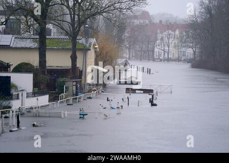 Lubeck, Germania. 3 gennaio 2024, Schleswig-Holstein, Lübeck: Sentieri e moli sulle rive del trave nel centro della città sono circondati da acque alluvionali. Sezioni della trave hanno già fatto esplodere le loro banche. La città anseatica di Lübeck ha avvertito del pericolo di inondazioni in alcune parti del centro città mercoledì. Secondo le previsioni, il livello dell'acqua dovrebbe raggiungere un'altezza di 1,05 metri sul livello del mare intorno alle 11,00, come annunciato dalla città. Foto: Marcus Brandt/dpa Foto Stock