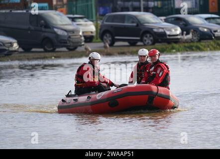 Northamptonshire vigili del fuoco e servizio di soccorso presso il Billing Aquadrome a Northampton dopo che le persone sulle case galleggianti sono state salvate dopo che il percorso di atterraggio è stato bloccato a causa dell'innalzamento dell'acqua causato da Storm Henk. Un grave allarme per le inondazioni, che significava pericolo per la vita, era in atto per il fiume Nene a Northampton, che metteva in guardia dall'acqua profonda e fluente nel parco vacanze Billing Aquadrome e nei vicini parchi commerciali. Data foto: Mercoledì 3 gennaio 2024. Foto Stock