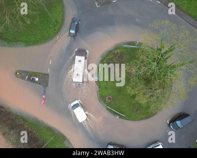 Hereford, Herefordshire, Regno Unito – mercoledì 3 gennaio 2024 – tempo nel Regno Unito – Vista aerea dei campi allagati e delle strade alla periferia di Hereford lungo la strada A4103 per Worcester. Questa inondazione proviene dal fiume Lugg con la strada locale per Sutton St Nicholas chiusa a questa rotatoria a causa delle inondazioni. Foto Steven May / Alamy Live News Foto Stock