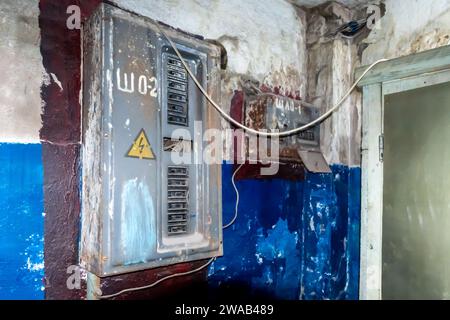 Vecchi interruttori elettrici sovietica in rovina sul muro malconcio dipinto in modo inadeguato nel corridoio della struttura di Almaty Foto Stock
