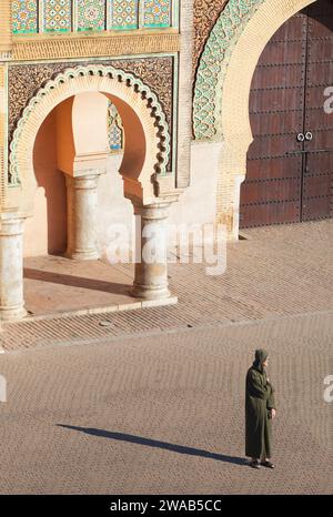 Un uomo anziano con una djellaba tradizionale di fronte alla porta Bab Mansour, Meknes, Marocco. Foto Stock