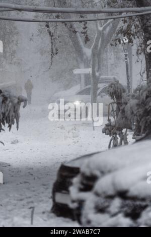 Strada cittadina sotto la neve durante la bufera della neve in inverno Foto Stock