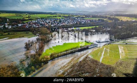 3 gennaio 2024, Assia, Fulda: Il Fulda, che è cresciuto bruscamente, ha fatto irruzione sulle sue rive nel distretto di Bronnzell e si è diffuso nei prati adiacenti e nel campo sportivo dell'SG Viktoria Bronnzell. Dopo le forti piogge di mercoledì e giovedì sera, fiumi e torrenti dell'Assia orientale, compresa la Fulda, scoppiarono le loro rive. Presso la stazione di misurazione nel distretto Fulda di Bronnzell, il livello del Fulda è addirittura salito al di sopra del terzo livello di segnalazione, dove, secondo l'ufficio statale, vi è un'inondazione eccezionale. (Foto scattata con un drone) foto: Andreas Arnold/dpa Foto Stock