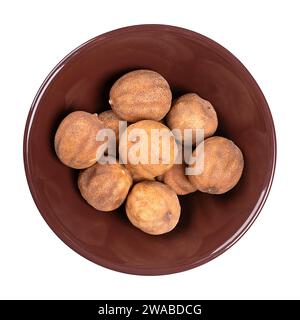 Lime secche intere, in un recipiente di ceramica marrone. Anche loomi, calce nera, noomi basra e limoo amani. Frutta fortemente aromatizzata, essiccata al sole. Foto Stock