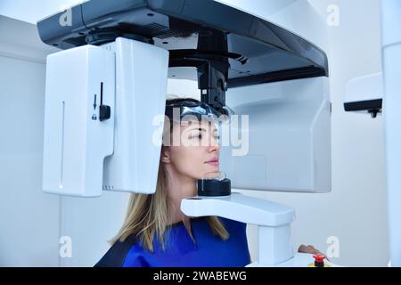 La paziente donna fa un tomografo panoramico al computer in clinica. Concetto di odontoiatria e assistenza sanitaria. Foto Stock