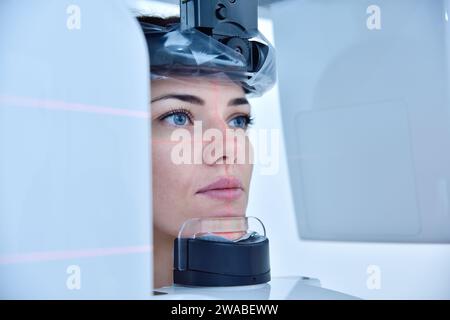 La paziente donna fa un tomografo dentale al computer in clinica. Concetto di odontoiatria e assistenza sanitaria. Foto Stock