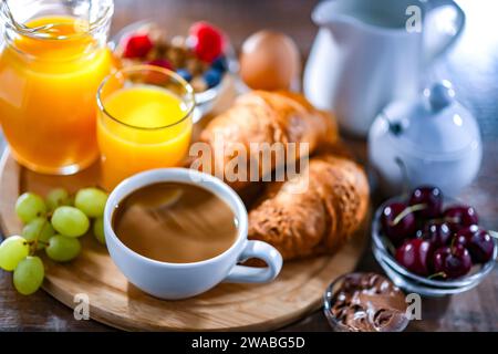 La colazione è servita con caffè, succo d'arancia, uova, cereali e croissant. Foto Stock