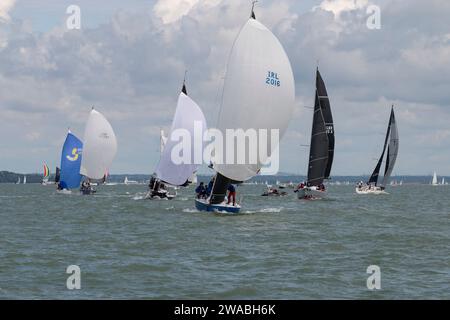 Un gruppo di yacht a vela a distanza ravvicinata durante una gara di barche a vela durante la Cowes Week Regatta. Cowes Week è un evento annuale che si tiene nell'IOW Foto Stock