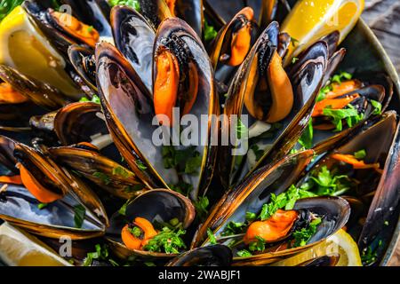 Composizione con un piatto di cozze al vapore servito con prezzemolo e limone Foto Stock