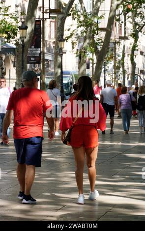 Barcellona, Spagna - 26 maggio 2022: Coppia vestita di rosse passeggiate lungo la Rambla nel centro della città di Barcellona. Foto Stock