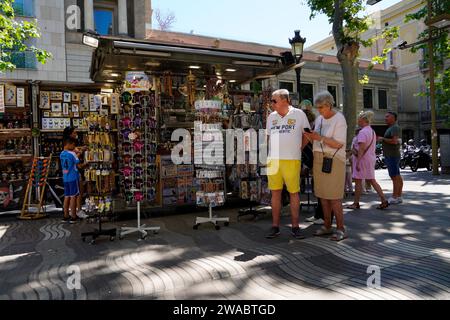 Barcellona, Spagna - 26 maggio 2022: Coppia sposata anziana in un viaggio turistico attraverso Barcellona davanti a un negozio di souvenir, mentre la donna usa Foto Stock