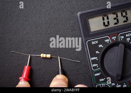 Verifica o misurazione del valore di un resistore con un multimetro. Foto Stock