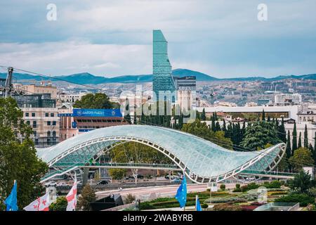 Vista sul Ponte della Pace e sul grattacielo dell'hotel Biltmore nella città vecchia di Tbilisi, Georgia Foto Stock