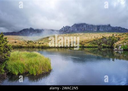 Il massiccio di Andringitra, visto dal campo base durante il trekking verso PIC Boby (la vetta più alta accessibile del Madagascar), un piccolo fiume che scorre in primo piano Foto Stock