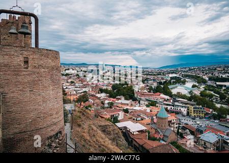 Vista della città vecchia di Tbilisi dalla fortezza di Narikala con il fiume Koura, il ponte della pace, l'hotel Biltmore (Georgia) Foto Stock