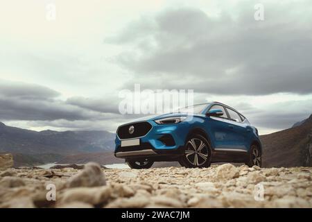 Tirana, Albania - 30 novembre 2023: Foto dell'angolo anteriore sinistro di un SUV 2023 MG ZS blu, scattato con il lago Bovilla sullo sfondo Foto Stock