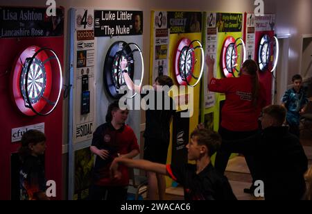 I membri del club locale di Luke Littler, la St Helen's Darts Academy, si allenano prima di vederlo giocare contro Luke Humphries nella finale del World Darts Championship. Il sedicenne è il giocatore più giovane di sempre a raggiungere il decisivo in un viaggio memorabile all'Alexandra Palace, ma dovrà affrontare il test più duro di sempre contro il nuovo numero uno del mondo mentre tenta di diventare il più giovane vincitore di sempre. Data foto: Mercoledì 3 gennaio 2024. Foto Stock