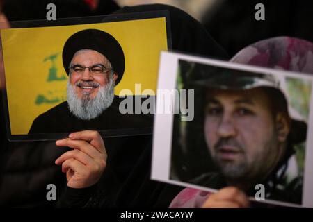 Beirut, Libano. 3 gennaio 2024. I sostenitori pro-iraniani di Hezbollah partecipano a una messa in quanto il Segretario generale di Hezbollah Hassan Nasrallah sembra tenere un discorso televisivo in occasione del quarto anniversario dell'assassinio di Abu Mahdi al-Mohandes, vice capo della milizia irachena di Hashd al-Shaabi, e il comandante della forza Quds iraniana Qasem Soleiman da un drone americano in Iraq nel 2020. Crediti: Marwan Naamnai/dpa/Alamy Live News Foto Stock