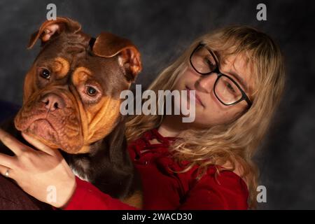 Amore gigante gentile: Un momento che fa scaldare il cuore si svolge mentre questo carino bullo XL fa venire l'affetto al proprietario, condividendo baci Foto Stock