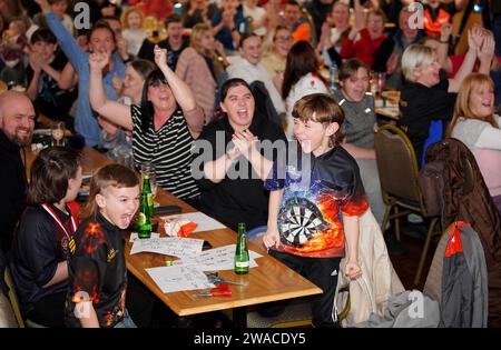 I membri del club locale di Luke Littler, la St Helen's Darts Academy, lo guardano giocare contro Luke Humphries nella finale del World Darts Championship. Il sedicenne è il giocatore più giovane di sempre a raggiungere il decisivo in un viaggio memorabile all'Alexandra Palace, ma dovrà affrontare il test più duro di sempre contro il nuovo numero uno del mondo mentre tenta di diventare il più giovane vincitore di sempre. Data foto: Mercoledì 3 gennaio 2024. Foto Stock