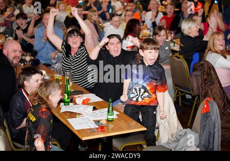 I membri del club locale di Luke Littler, la St Helen's Darts Academy, lo guardano giocare contro Luke Humphries nella finale del World Darts Championship. Il sedicenne è il giocatore più giovane di sempre a raggiungere il decisivo in un viaggio memorabile all'Alexandra Palace, ma dovrà affrontare il test più duro di sempre contro il nuovo numero uno del mondo mentre tenta di diventare il più giovane vincitore di sempre. Data foto: Mercoledì 3 gennaio 2024. Foto Stock