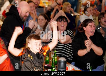 I membri del club locale di Luke Littler, la St Helen's Darts Academy, lo guardano giocare contro Luke Humphries nella finale del World Darts Championship. Il sedicenne è il giocatore più giovane di sempre a raggiungere il decisivo in un viaggio memorabile all'Alexandra Palace, ma dovrà affrontare il test più duro di sempre contro il nuovo numero uno del mondo mentre tenta di diventare il più giovane vincitore di sempre. Data foto: Mercoledì 3 gennaio 2024. Foto Stock