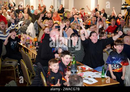 I membri del club locale di Luke Littler, la St Helen's Darts Academy, lo guardano giocare contro Luke Humphries nella finale del World Darts Championship. Il sedicenne è il giocatore più giovane di sempre a raggiungere il decisivo in un viaggio memorabile all'Alexandra Palace, ma dovrà affrontare il test più duro di sempre contro il nuovo numero uno del mondo mentre tenta di diventare il più giovane vincitore di sempre. Data foto: Mercoledì 3 gennaio 2024. Foto Stock