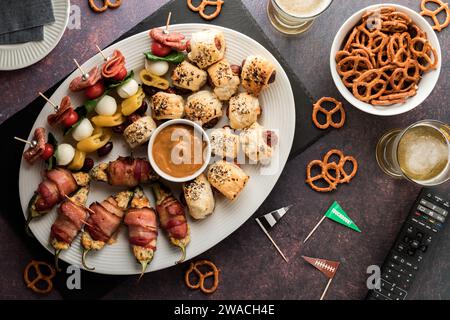 Un piatto di antipasti del giorno della partita con birra e pretzel. Foto Stock