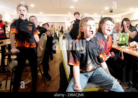 I membri del club locale di Luke Littler, la St Helen's Darts Academy, lo guardano giocare contro Luke Humphries nella finale del World Darts Championship. Il sedicenne è il giocatore più giovane di sempre a raggiungere il decisivo in un viaggio memorabile all'Alexandra Palace, ma dovrà affrontare il test più duro di sempre contro il nuovo numero uno del mondo mentre tenta di diventare il più giovane vincitore di sempre. Data foto: Mercoledì 3 gennaio 2024. Foto Stock