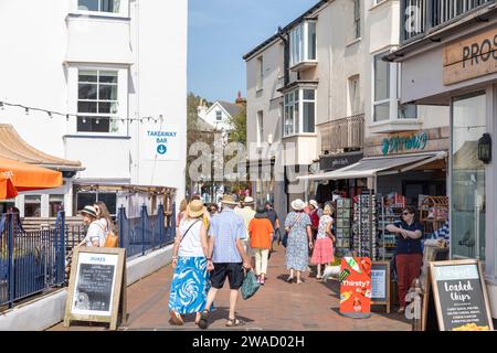 Gli amanti dello shopping camminano attraverso il centro di Sidmouth passando per caffetterie e negozi, Devon, Inghilterra, Regno Unito, 2023 Foto Stock