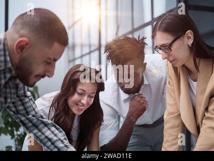 Gruppo di giovani uomini d'affari che lavorano insieme mentre si trovano in ufficio creativo Foto Stock