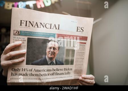 Parigi, Francia - 15 novembre 2023: Una donna legge l'ultimo Financial Times, con l'ex primo ministro britannico David Cameron come ministro degli Esteri e un articolo sulle prospettive finanziarie degli americani sotto Biden Foto Stock