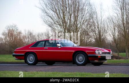 Stony Stratford, Regno Unito, 1 gennaio 2024. 1989 auto Jaguar XJS rossa in arrivo a Stony Stratford per l'annuale festa dei veicoli d'epoca e classici del Capodanno Foto Stock