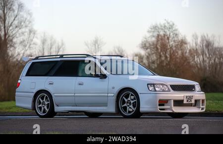 Stony Stratford, Regno Unito, 1 gennaio 2024. 1998 Nissan Stagea station wagon in arrivo a Stony Stratford per l'annuale veicolo d'epoca e classico del giorno di Capodanno f Foto Stock