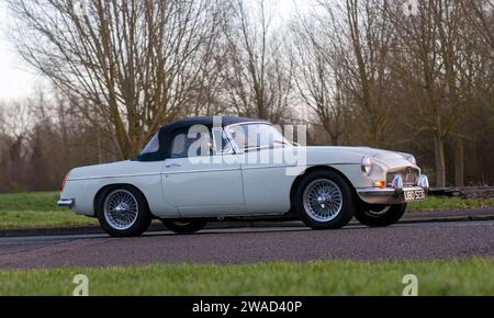 Stony Stratford, Regno Unito, 1 gennaio 2024. 1969 auto sportiva MG C bianca in arrivo a Stony Stratford per l'annuale festi di Capodanno Foto Stock