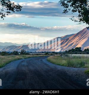 USA, Idaho, Bellevue, strada sterrata che conduce alle colline pedemontane la sera d'estate Foto Stock
