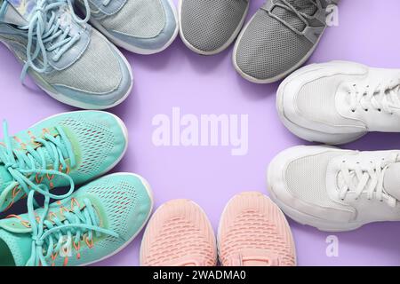 Montatura realizzata con sneaker eleganti e diverse su sfondo viola Foto Stock