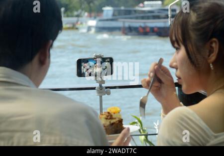 Una coppia asiatica di generazione Z che filma se stessa per un vlog online sulla loro piattaforma di social media. Bangkok, Thailandia. Foto Stock