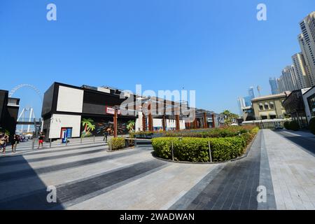 Ristoranti e caffetterie lungo la passeggiata sulla spiaggia presso la Marina Beach di Dubai, Emirati Arabi Uniti. Foto Stock