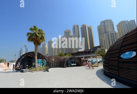 Ristoranti e caffetterie lungo la passeggiata sulla spiaggia presso la Marina Beach di Dubai, Emirati Arabi Uniti. Foto Stock