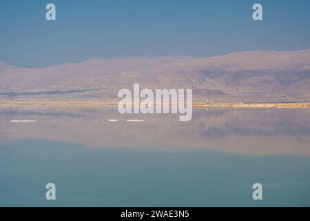 Paesaggio del Mar morto, montagne aride che si riflettono sul lago di superficie Foto Stock